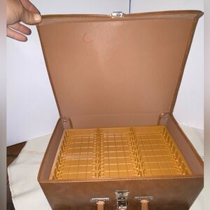 Vintage brown faux leather briefcase-style storage container holds 60 cassettes